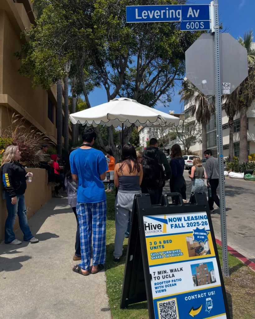 Students at an event stand learning about The Hive Glenrock - Furnished apartments near UCLA