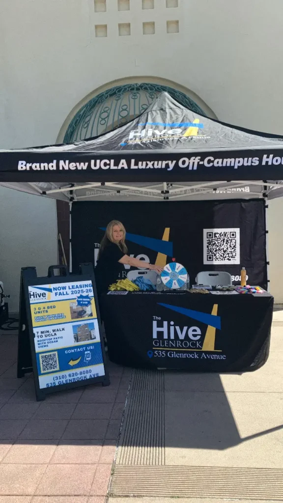 Staff member managing The Hive Apartments information stand - Apartments near UCLA